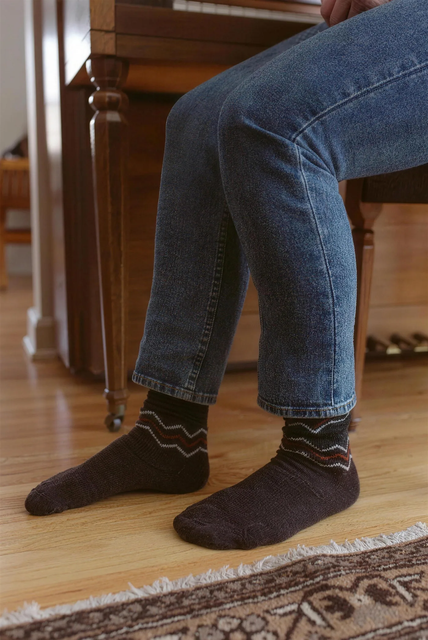 Norweger-Alpakasocken in Braun, sitzend, mit Jeans